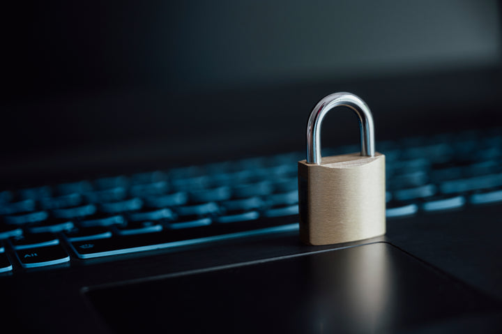 Ein goldenes Vorhängeschloss auf der Laptop-Computertastatur in einem konzeptionellen Bild der Online-Cybersicherheit.